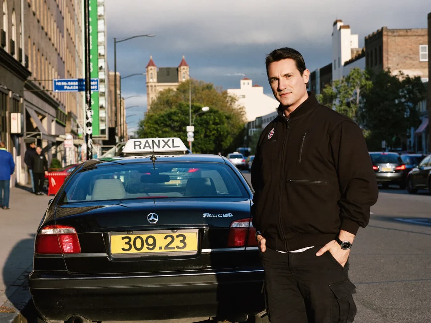 A Birmingham private hire driver beside his plated replacement car